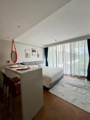 a bedroom with a bed and a desk with a mirror at Beach Resort along coastline of Layan beach in Layan Beach
