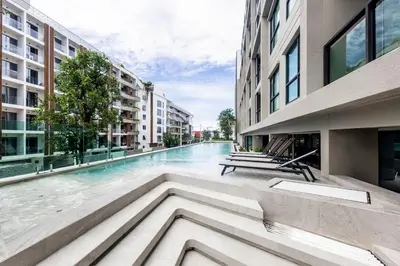 a swimming pool in the middle of a building at Modern apartment in the heart of Bangtao in Ban Thalat Choeng Thale