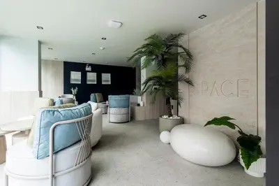 a living room with white chairs and a table at Modern apartment in the heart of Bangtao in Ban Thalat Choeng Thale