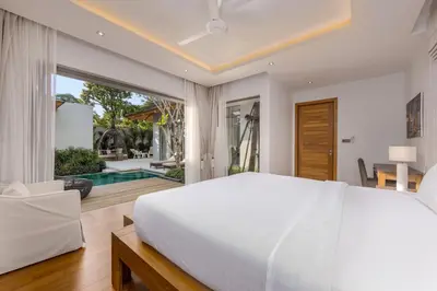 a bedroom with a large white bed and a pool at Modern 3BR Villa Kaimana with Private Pool in Ban Phru Champa
