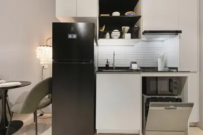 a kitchen with a black refrigerator and a microwave at Studio with a terrace in The Title Legendary in Bang Tao Beach