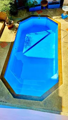 a swimming pool with blue water in a yard at For 3 Person in Central Pa Tong, Thailand in Patong Beach