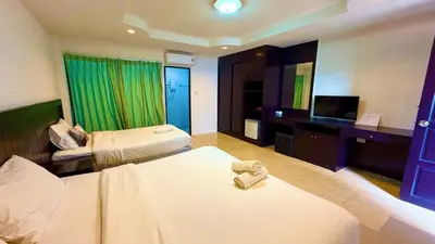 a hotel room with two beds and a flat screen tv at For 3 Person in Central Pa Tong, Thailand in Patong Beach