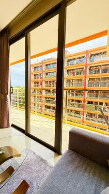 a living room with a glass table and large windows at Bright Sun Apartment with Pools in Rawai Beach