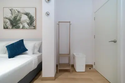 a white bedroom with a bed and a mirror at Espuma Patong pool villa in Patong Beach