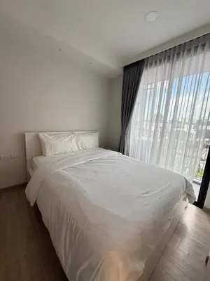 a white bed in a bedroom with a large window at Sky Park Family Comfort in Laguna Phuket