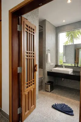 a bathroom with a wooden door and a sink at Private Pool Villa Baan Bua in Phuket Town