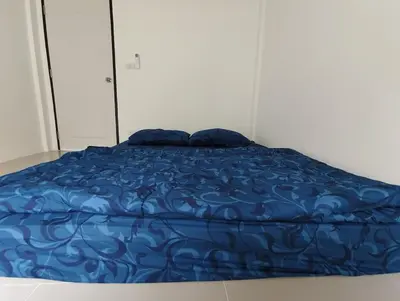 a bed with a blue comforter and two pillows at The Blue Oasis Cozy Phuket Getaway in Ban Ket Ho