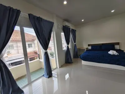 a bedroom with a blue bed and a large window at The Blue Oasis Cozy Phuket Getaway in Ban Ket Ho