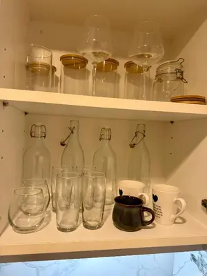 a shelf with glass bottles and cups on it at Luxury 112 m 2BR, Direct Pool Access, 1st Line, Klong Muang Beach in Ban Ko Kwang