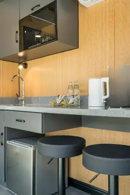 a kitchen with two bar stools at a counter at Apple House seaside home and pool in Ban Lum Fuang