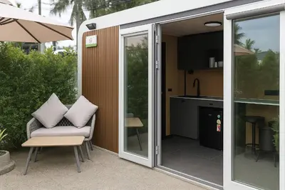 a screened in patio with a chair and a kitchen at Apple House Phuket a cozy home terrace &pool&beach in Ban Lum Fuang