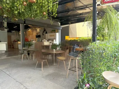a restaurant with tables and chairs and plants at Apple House Bangtao with terrace Pool & Beach in Ban Lum Fuang