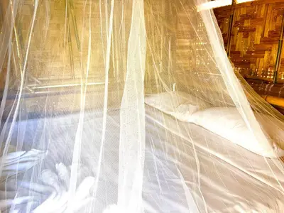 a bed with a white mosquito net at Patong Canal House 3 in Patong Beach
