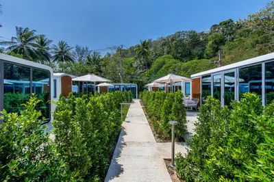 a row of plants in front of a building at Seaside Apple House, Pool & Morning Breakfast in Ban Lum Fuang