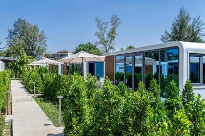 a house in a garden with umbrellas at Apple House Bangtao Beach pool, terrace, breakfast in Ban Lum Fuang