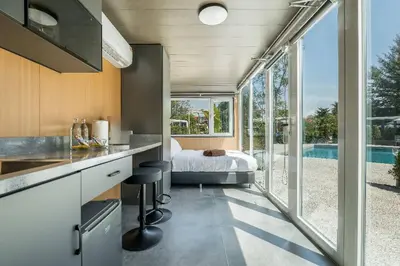 a kitchen and bedroom with a bed and a large window at Apple House Phuket Near Beach with Pool & Terrace in Ban Lum Fuang