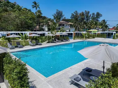 an image of a swimming pool at a resort with umbrellas at Apple House Phuket Near Beach with Pool & Terrace in Ban Lum Fuang