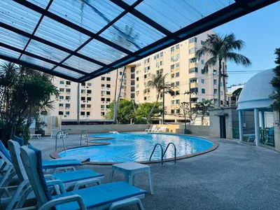 a large swimming pool with chairs and a building at Lahan 4 in Patong Beach