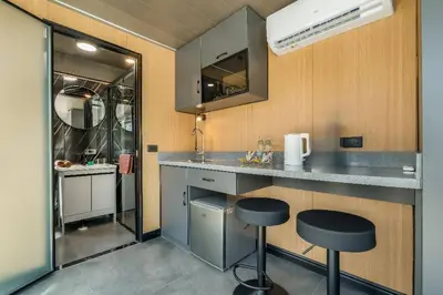 a small kitchen with two stools and a counter at Apple House Bangtao with Pool & Terrace, beach in Ban Lum Fuang