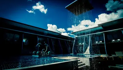 a building with a fountain in front of a building at The Phu Beach Hotel - SHA Plus in Ao Nang Beach