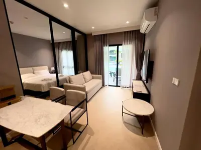 a hotel room with a bed and a table and chairs at The Title Legendary Bang-Tao access to the pool in Bang Tao Beach
