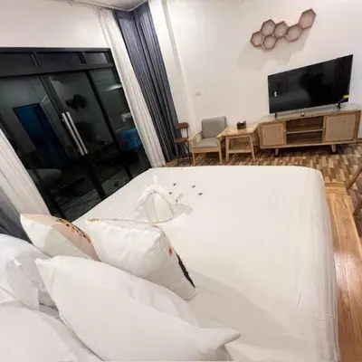 a living room with a white couch and a tv at Stingless Villa in Ban Ket Ho