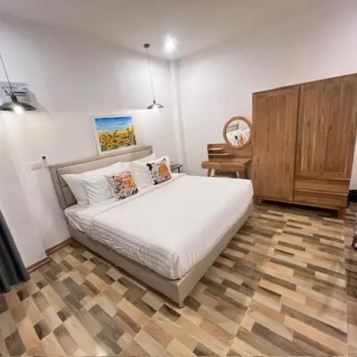 a bedroom with a white bed and a wooden cabinet at Stingless Villa in Ban Ket Ho