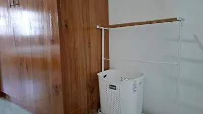 a bathroom with a trash can and a wooden wall at Gentle Guesthouse in Patong Beach