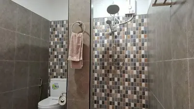a bathroom with a shower with a toilet in it at Gentle Guesthouse in Patong Beach