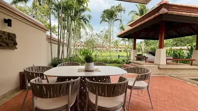 a patio with a white table and chairs at Tropical Thai style 4 bedroom pool villa in Laguna Phuket