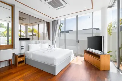 a bedroom with a white bed and a television at V277 Famous Ozone Resort Calm Area Near Beach in Thalang
