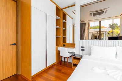 a bedroom with a bed and a desk and a chair at V277 Famous Ozone Resort Calm Area Near Beach in Thalang
