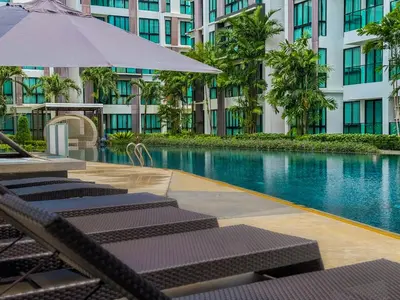 a hotel swimming pool with lounge chairs and an umbrella at Cozy 1 Bdr Royal Lee Nayang beach in Ban Bo Han