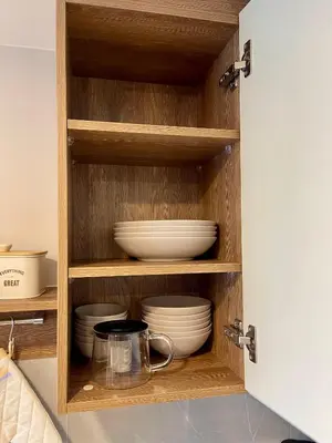 a cupboard with plates and bowls in it at Family Space Condo 2 Bdr BangTao in Ban Thalat Choeng Thale