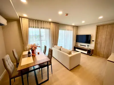 a living room with a table and a white couch at Family Space Condo 2 Bdr BangTao in Ban Thalat Choeng Thale