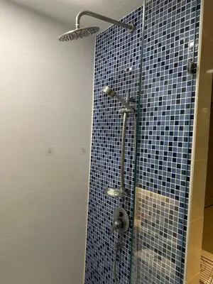 a bathroom with a shower with a blue tiled wall at Cozy Condo with full kitchen Patong in Patong Beach