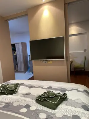 a bedroom with a bed with two green towels on it at Cozy Condo with full kitchen Patong in Patong Beach