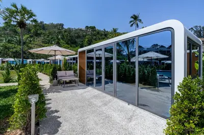 a glass house with a chair and an umbrella at Beachside Apple House Pool & Terrace in Bangtao in Ban Lum Fuang