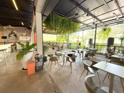 a restaurant with tables and chairs and people in the background at Apple House Seaside Escape with Pool & Breakfast in Ban Lum Fuang