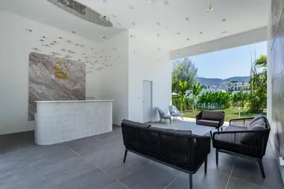 a living room with a couch and chairs and a fireplace at Apple House Seaside Escape with Pool & Breakfast in Ban Lum Fuang