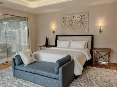 a bedroom with a bed and a blue chair at Luxury Botanica Villa in Ban Phru Champa