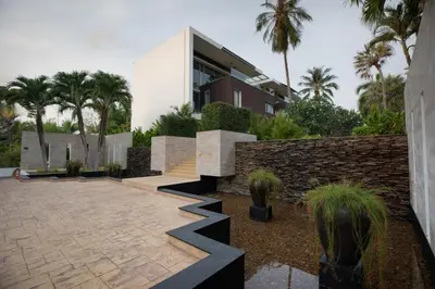 a building with palm trees in front of a courtyard at Peaceful Penthouse @ Lotus Gardens Layan Beach in Layan Beach