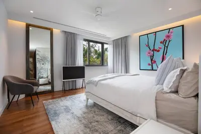 a bedroom with a bed and a television in it at Peaceful Penthouse @ Lotus Gardens Layan Beach in Layan Beach