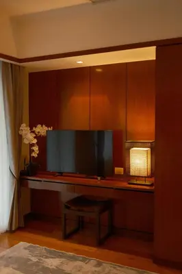 a living room with a flat screen tv and a stool at Bursuai - Lake view family pool Laguna Village in Ban Thalat Choeng Thale