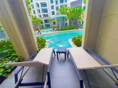 a balcony with two chairs and a swimming pool at title legendary in Bang Tao Beach