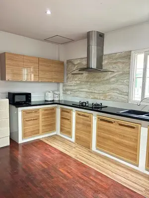 a kitchen with wooden cabinets and black counter tops at NS Private Pool villa in Ban Na Kok