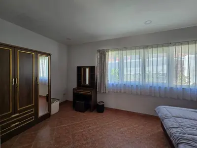 a bedroom with a bed and a dresser and windows at B&K private pool Villa in Rawai Beach
