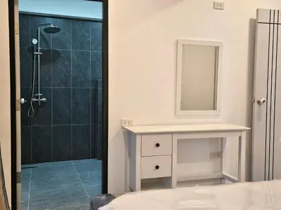 a bathroom with a shower and a sink and a mirror at Kamala House in Kamala Beach