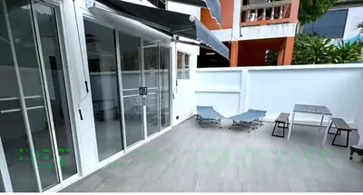 a balcony with chairs and tables on a building at Kamala House in Kamala Beach